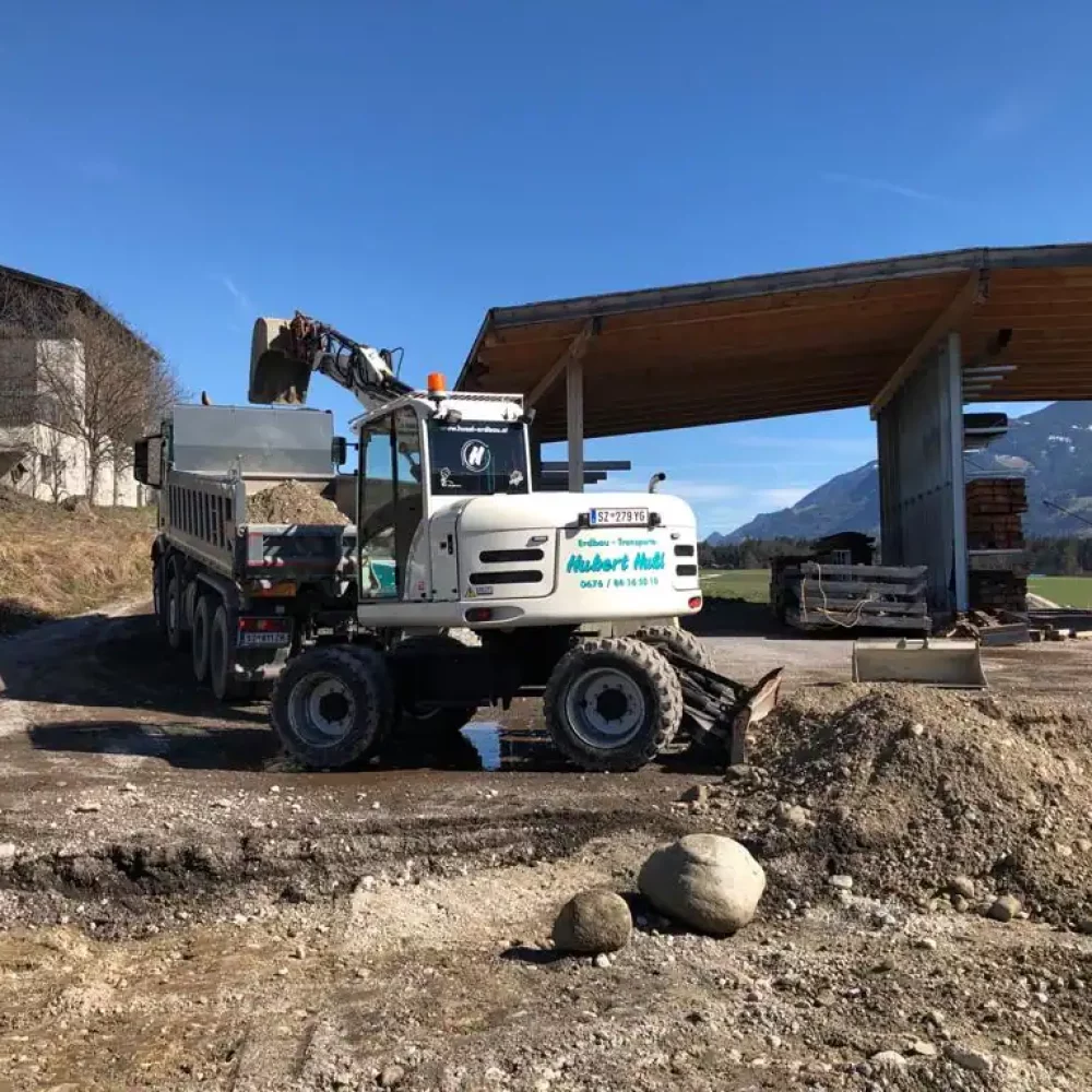 Bagger beladet einen LKW Hussl Erdbau Transporte
