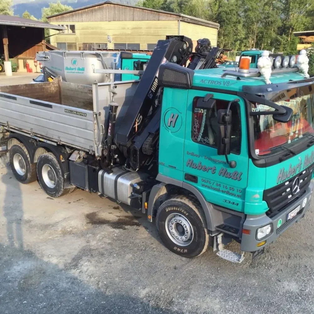 Fuhrpark der Firma Hussl Erdbau Transporte aus Terfens in Tirol. LKW 3 Achser mit Kran.